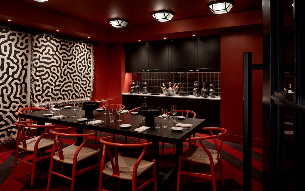 Dining area with table set for a dinner party in a dimly lit private dining area at Lyle DC.