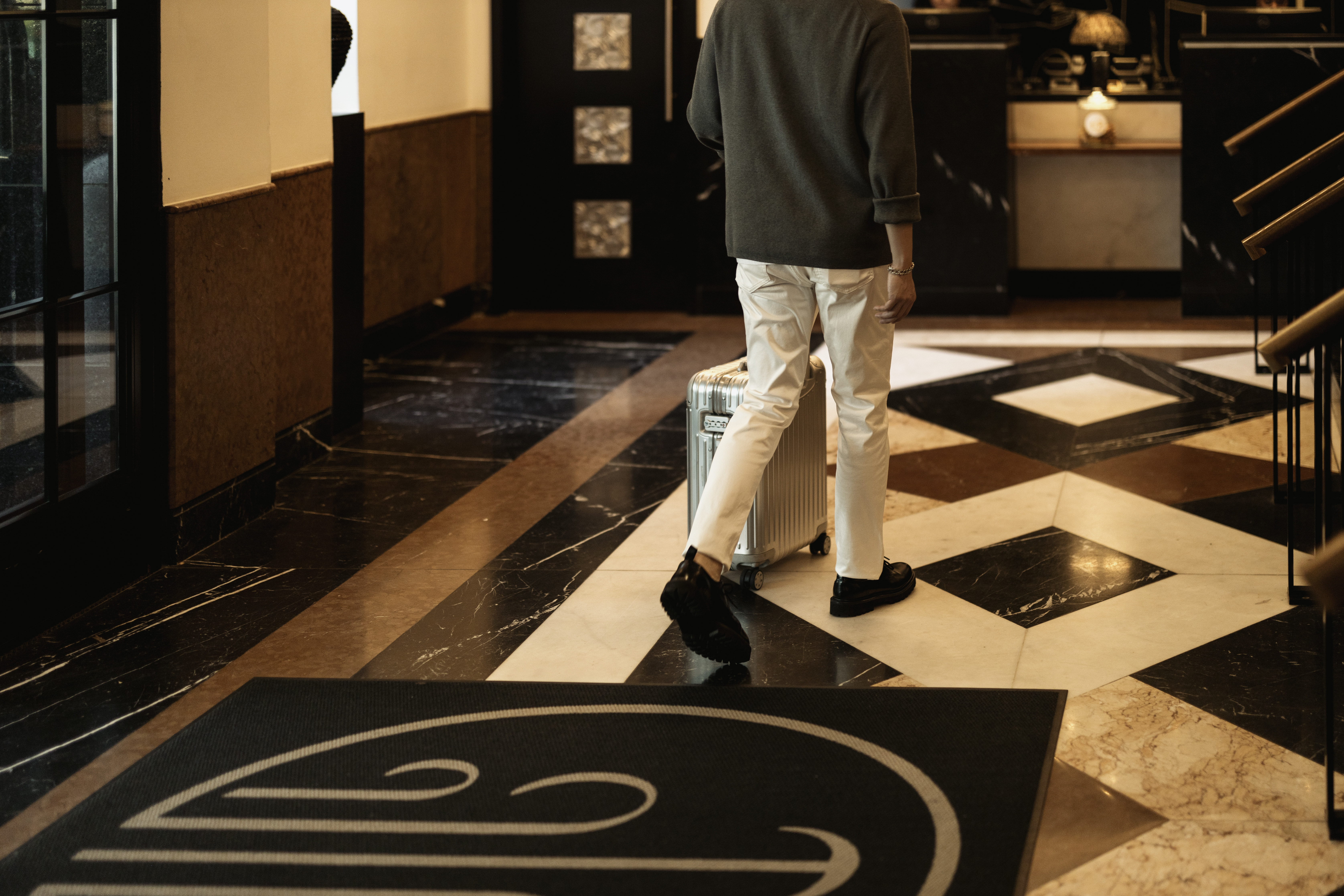a person walking with luggage in a lobby