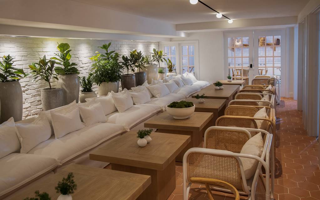 The Conservatory row of wooden table and white chairs.