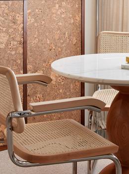 A close-up of contemporary wooden chairs around a sleek marble table, showcasing modern decor and earthy tones at Lyle DC.