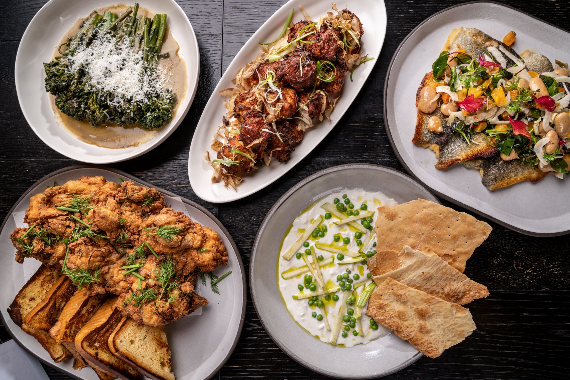 A selection of plated dishes on a dark wooden table