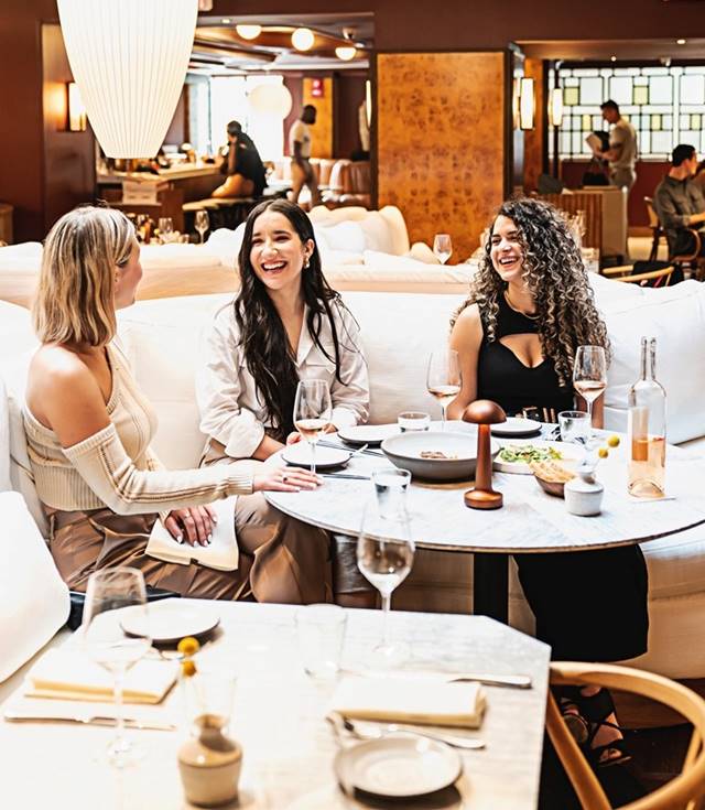 Three women eating and drinking in Lyle's Restaurant and Bar