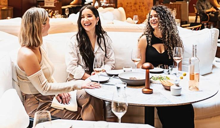 Three women eating and drinking in Lyle's Restaurant and Bar
