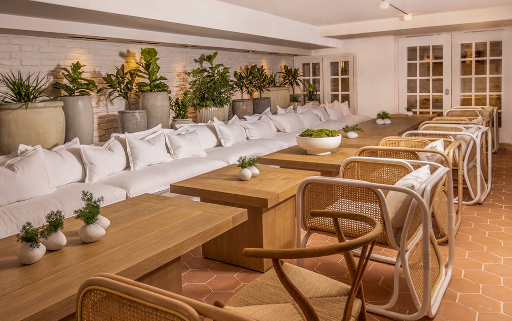 Long tables along white couches in the Conservatory at the Lyle DC.