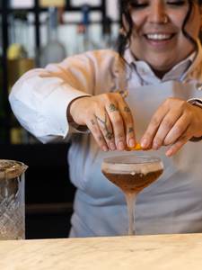 Bartender placing garnish on drink