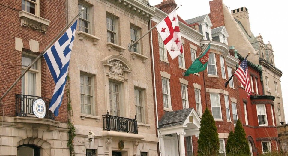 A historic building with flags flying from its facade