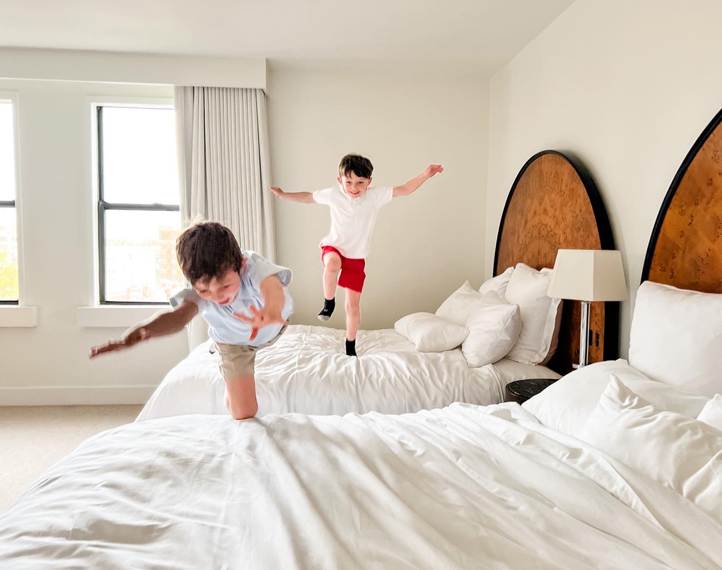 Children jumping on beds in the family-friendly Lyle DC hotel.