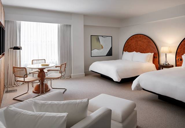 Bedroom with two beds and chaise at Lyle DC hotel.
